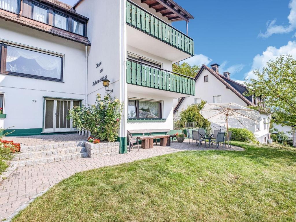 une image d'une maison avec une terrasse et une pelouse dans l'établissement Apartment with terrace in Sauerland region, à Medebach