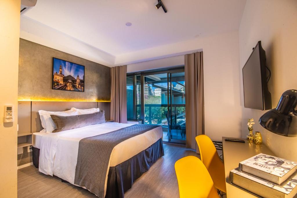 a hotel room with a bed and a table and chairs at 360 República in Sao Paulo