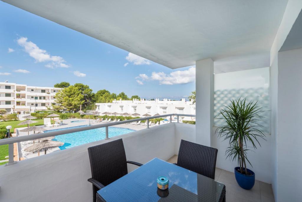 a balcony with a table and chairs and a swimming pool at Camelina Suites in San Antonio Bay