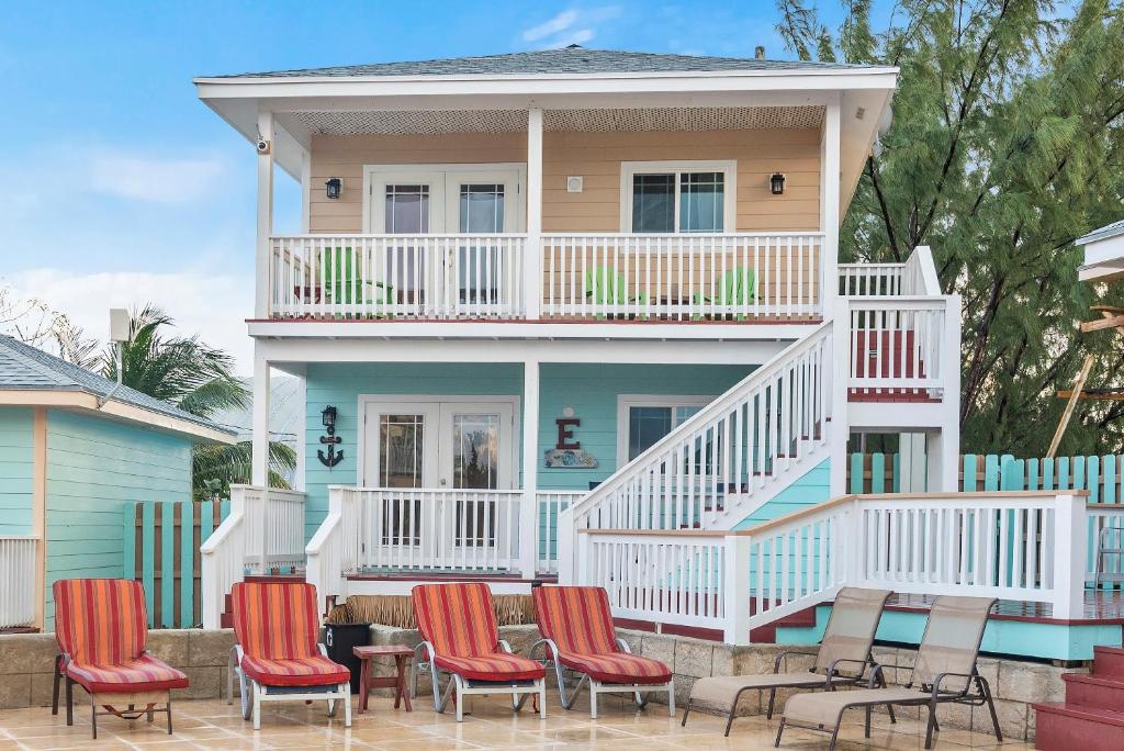 Staniel CayにあるEMBRACE Resortのデッキと椅子が前にある家