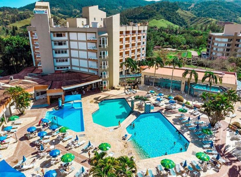 uma vista aérea de um resort com uma piscina e cadeiras em Flats termais em condomínio Apart Hotel de águas termais em Gravatal