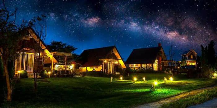 eine nächtliche Aussicht auf ein Haus mit Sternenhimmel in der Unterkunft ไอหมอก ชาเล่ต์ in Wang Nam Khieo