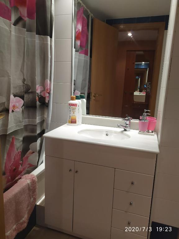 Un baño con un lavabo blanco y un espejo. en TU CASA EN MEQUINENZA CON WIFI, en Mequinenza