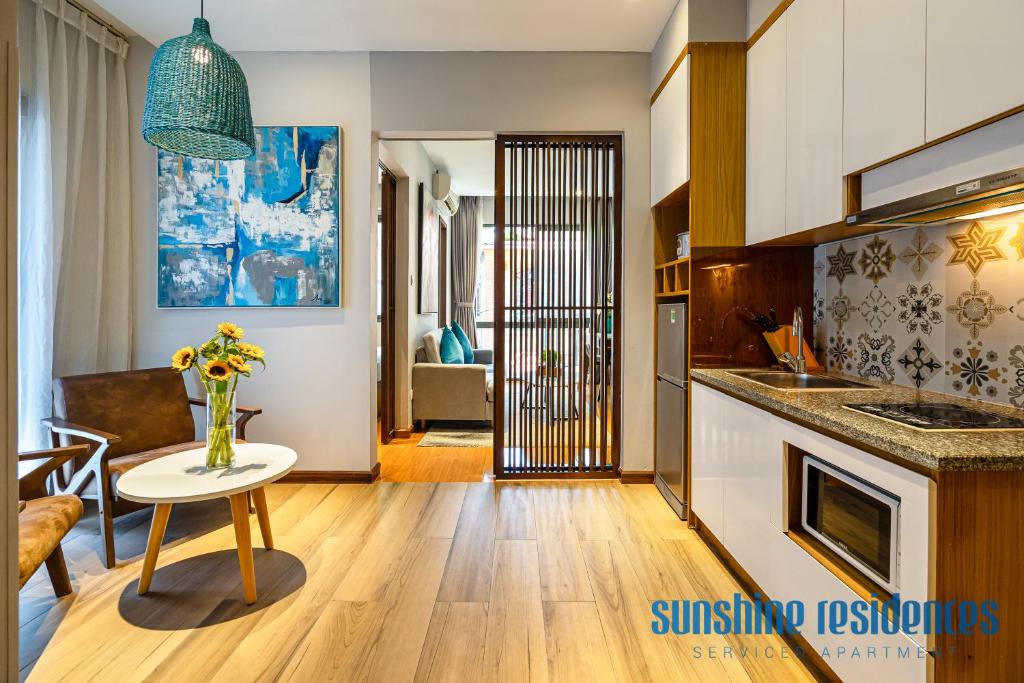 a kitchen with a vase of flowers on a table at The Art - Sunshine Apartment in Ho Chi Minh City