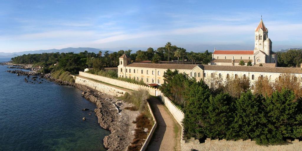 a large building next to a body of water at Hotel America in Cannes