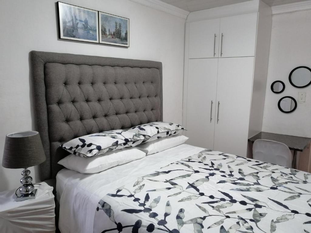 a bedroom with a bed with a black and white comforter at RonVu @ Bertram in East London
