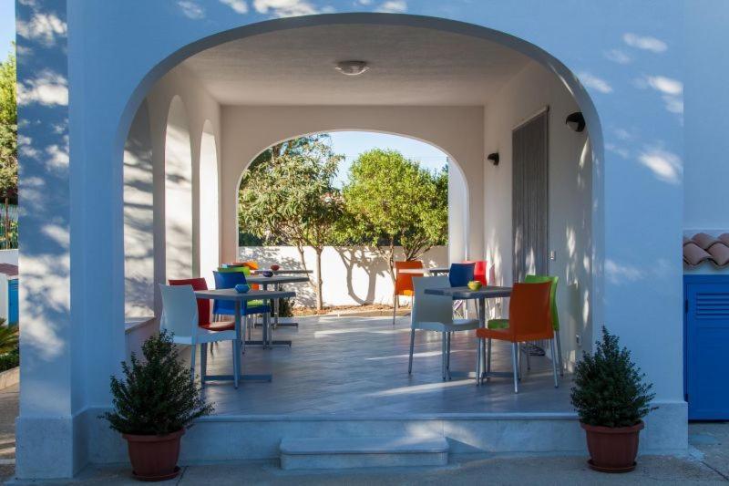 un arco con sedie e tavoli colorati su un patio di B&B "Perla del Sud" a San Vito lo Capo