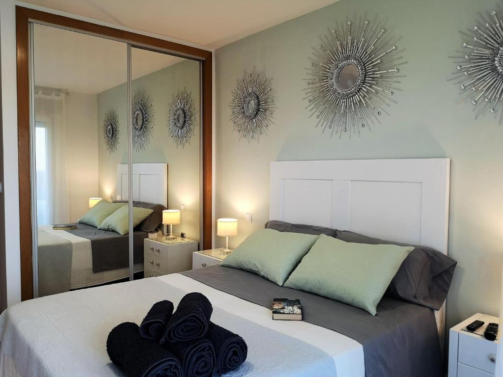 ein Schlafzimmer mit einem Bett mit einem Spiegel und Handtüchern darauf in der Unterkunft El remanso II in La Manga del Mar Menor