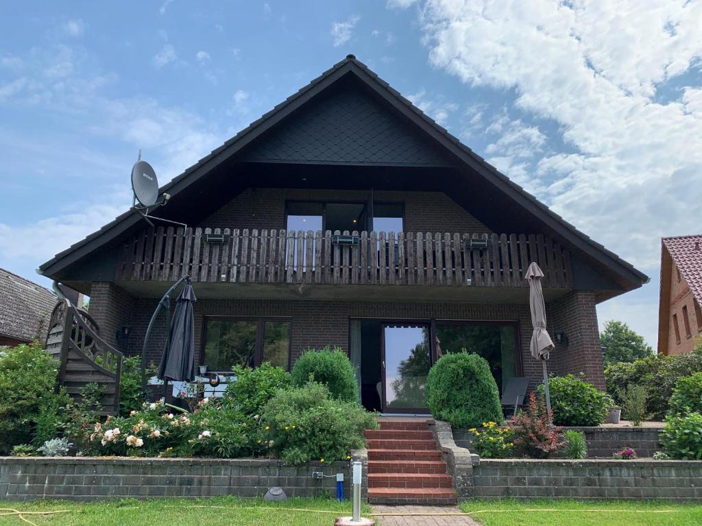 a house with a porch and a balcony at Ferienwohnung Dustin in Neuenkirchen