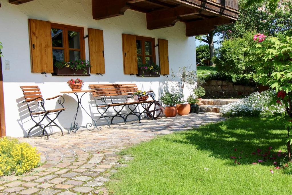 a patio with two chairs and a table in front of a house at Ferienwohnung Fanese in Flintsbach