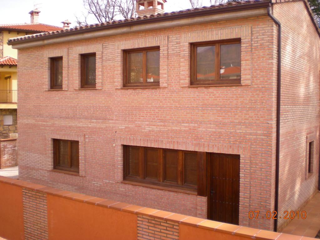 un edificio de ladrillo con ventanas laterales en El Refugio del Tiétar, en La Adrada