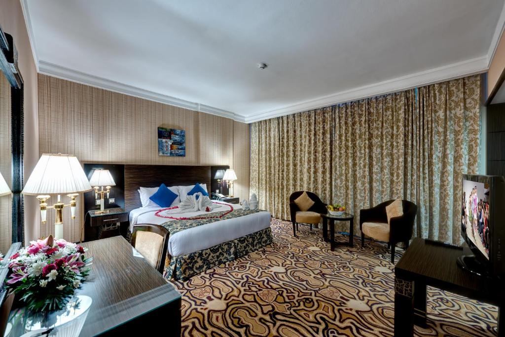 a hotel room with a bed and a desk at Sharjah Palace Hotel in Sharjah