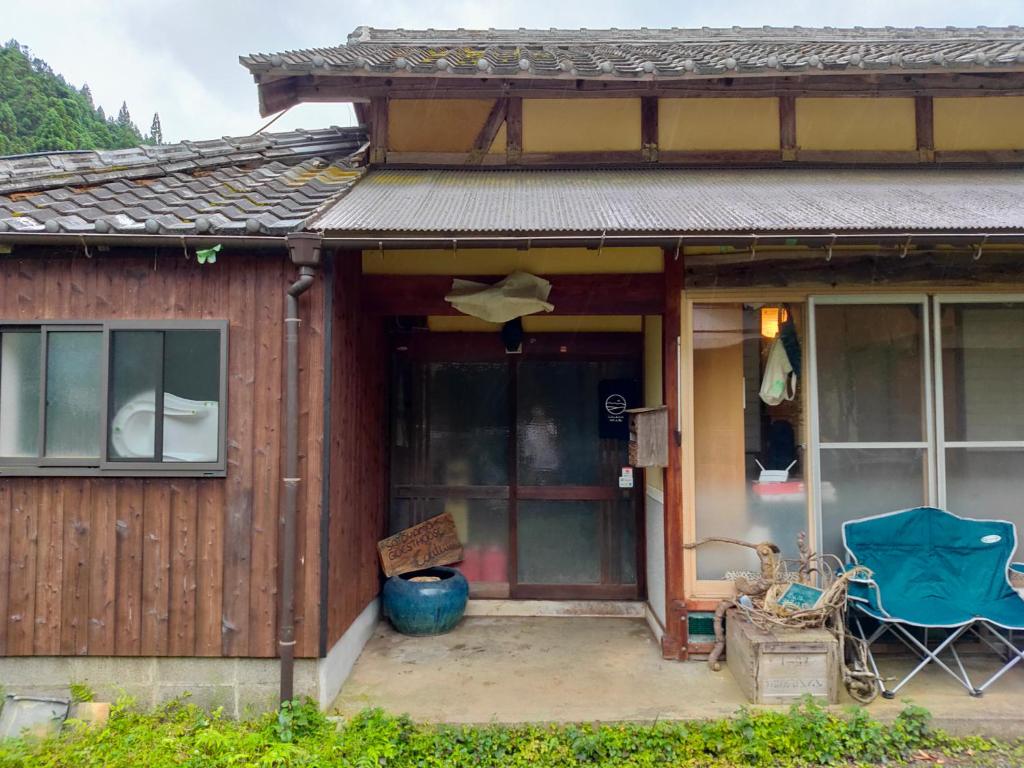 een huis met een blauwe stoel ervoor bij Satoyama Guest House Couture in Ayabe