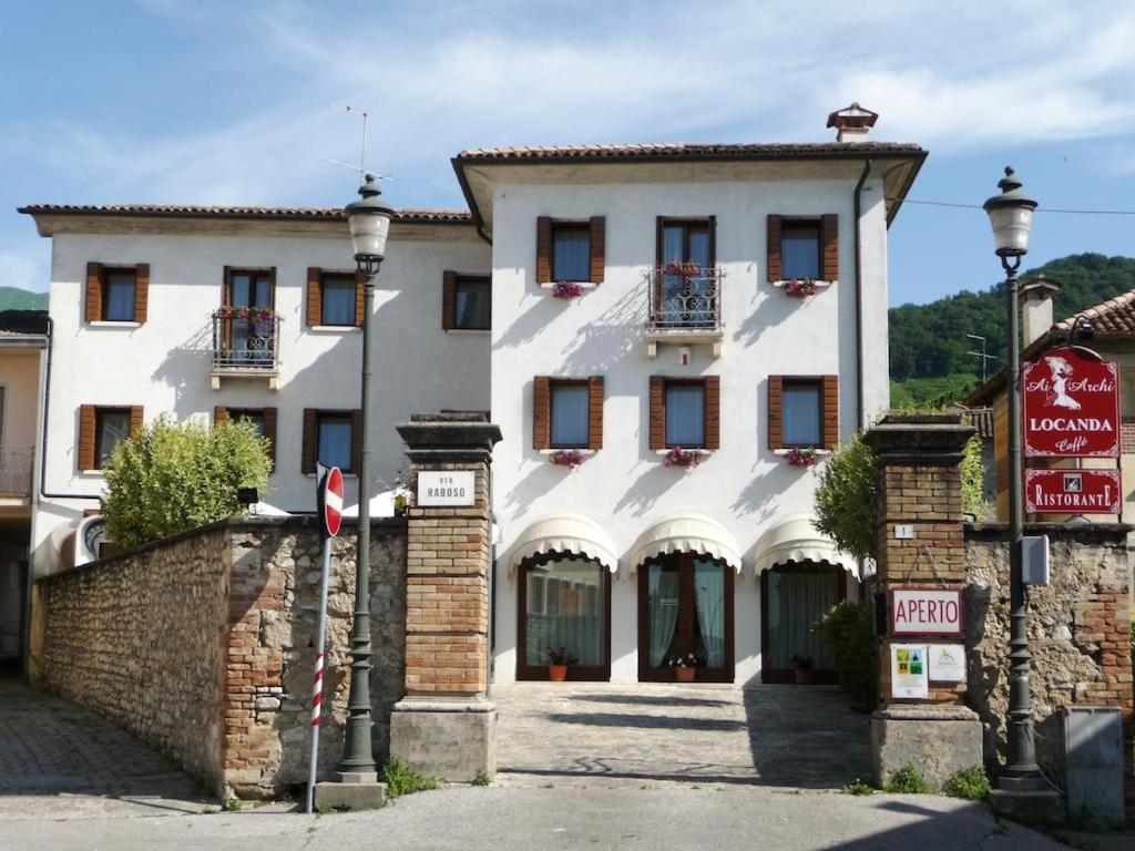 um grande edifício branco com uma placa em frente em Locanda Ai Archi Di Andreola Monica em Farra di Soligo