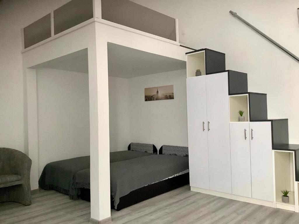 ミシュコルツにあるBelvárosi Apartman 1のベッドルーム1室(ベッド1台、ロフトベッド1台付)