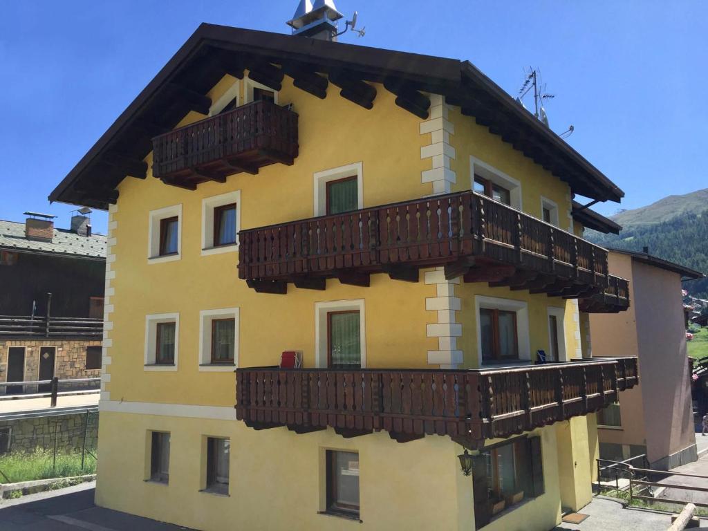 a yellow building with wooden balconies on it at Appartamenti Alba in Livigno