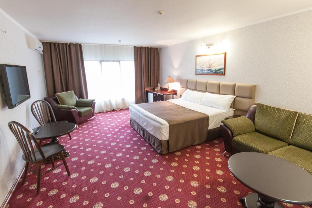 ピャチゴルスクにあるОтель Наутилусのベッド、椅子、テレビが備わるホテルルームです。