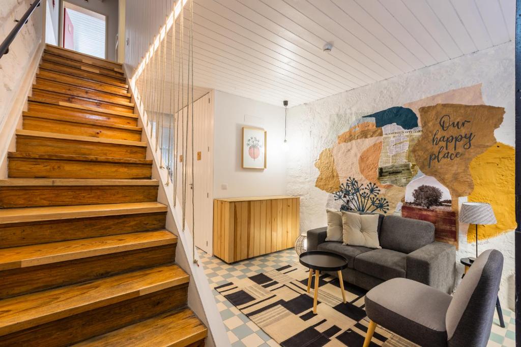uma sala de estar com uma escada e um sofá em Victoria Studios @ Clérigos no Porto