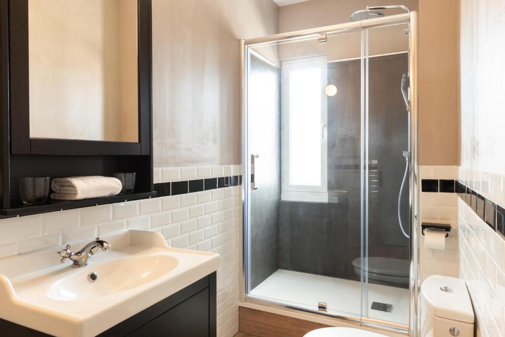 a bathroom with a sink and a glass shower at The Originals Boutique, Hôtel Victoria, Châtelaillon-Plage in Châtelaillon-Plage