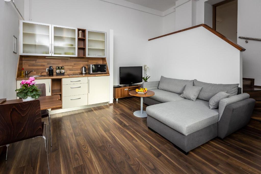 a living room with a couch and a table at Vinosseum Bor- és Apartmanház in Sopron