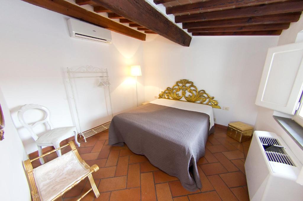 ein Schlafzimmer mit einem Bett und einem Stuhl in der Unterkunft TRAVIATA APPARTAMENTO STORICO - PALAZZO TOLOMEI in Florenz