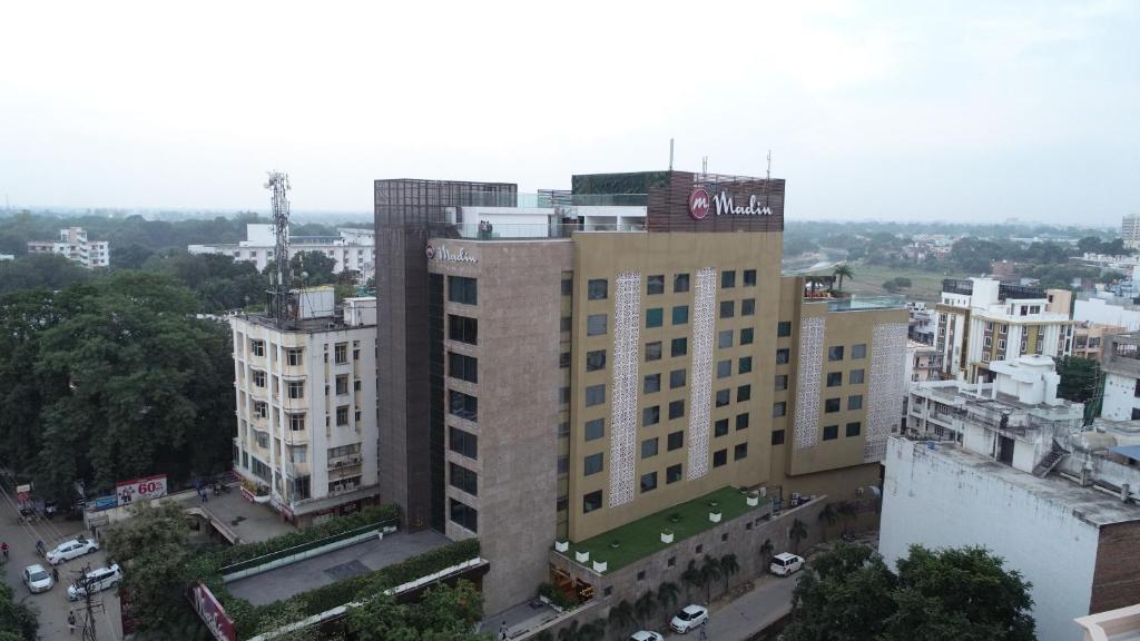 wysoki budynek z znakiem na górze w obiekcie Hotel Madin w mieście Waranasi