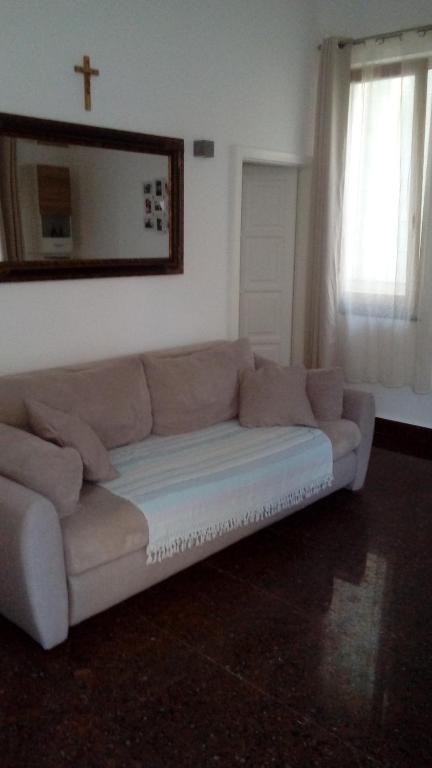 a couch in a living room with a cross on the wall at Apartmani Belvedere in Novigrad Istria