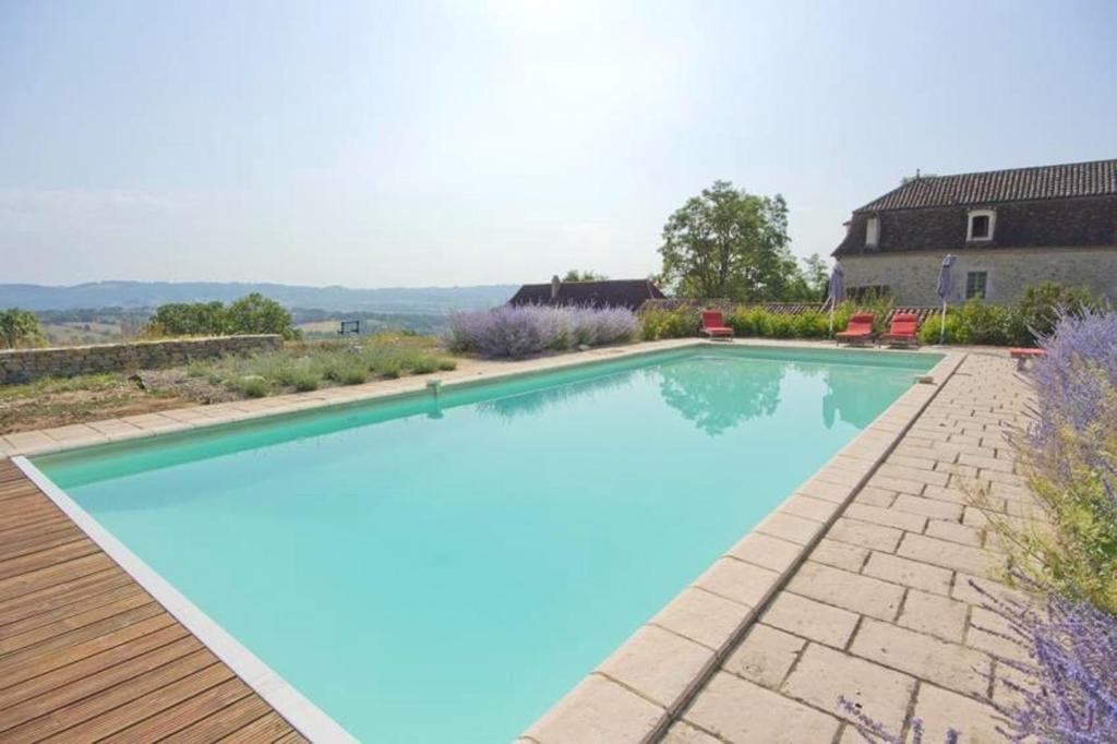 uma piscina com água azul num quintal em Villa de 5 chambres avec piscine privee jardin amenage et wifi a Fons em Fons