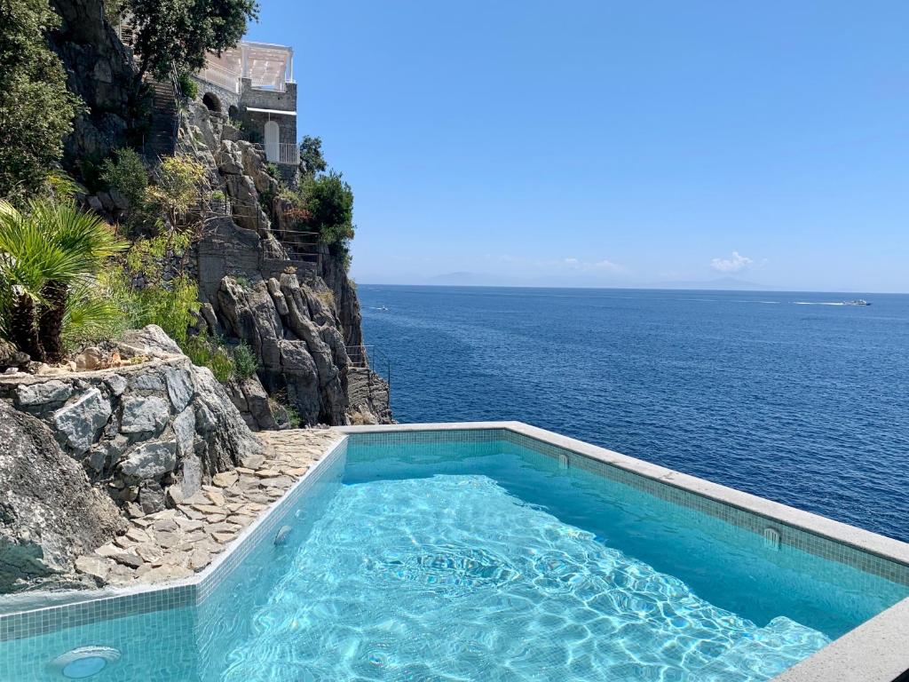 a swimming pool with the ocean in the background at Villa Le Baste in Furore