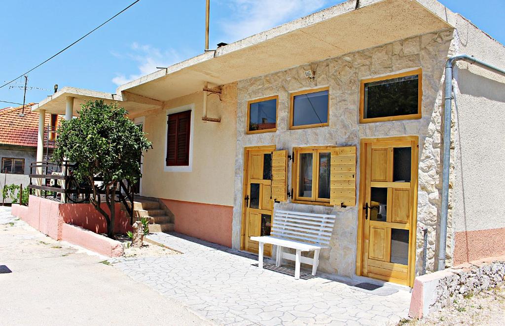 une maison avec un banc devant elle dans l'établissement Studio Apartman Zara, à Zadar
