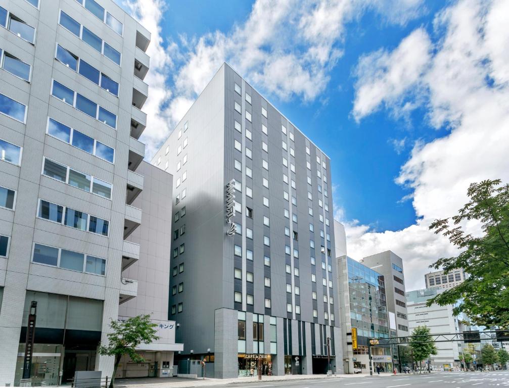 un edificio blanco alto en una calle de la ciudad en JR Inn Sapporo Kita 2 Jo en Sapporo