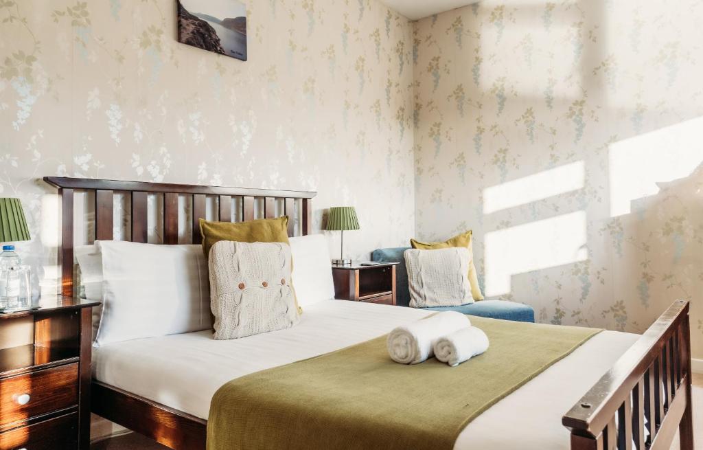 um quarto com uma cama grande e uma cadeira em Three Wells B&B em Llandrindod Wells