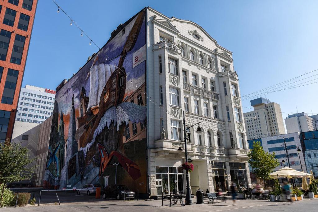 a building with a large mural on the side of it at Dream Aparts - Piotrkowska 152 in Łódź