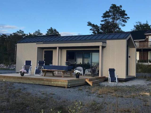 een klein huis met een picknicktafel en stoelen bij Hytte med sjøutsikt og 20 min fra dyreparken in Grimstad