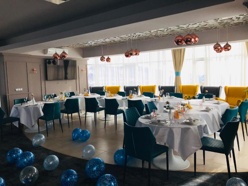 沃萊尼德蒙泰的住宿－Hotel Afrodita -Valenii De Munte，一间带桌椅和蓝色气球的用餐室