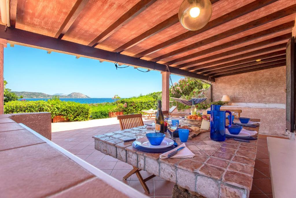 una mesa en un patio con vistas al océano en Costa Corallina Villa con spiaggia sotto casa e vista meravigliosa, en Costa Corallina