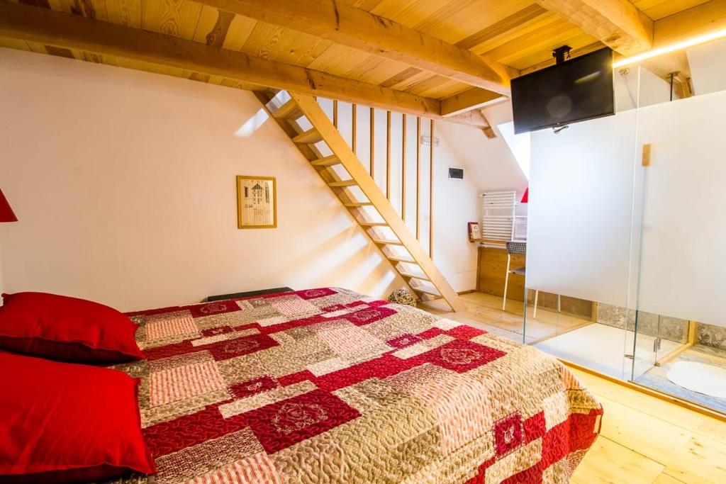 a bedroom with a bed with a red quilt at Camere Bar Rudi in Santa Maria Maggiore