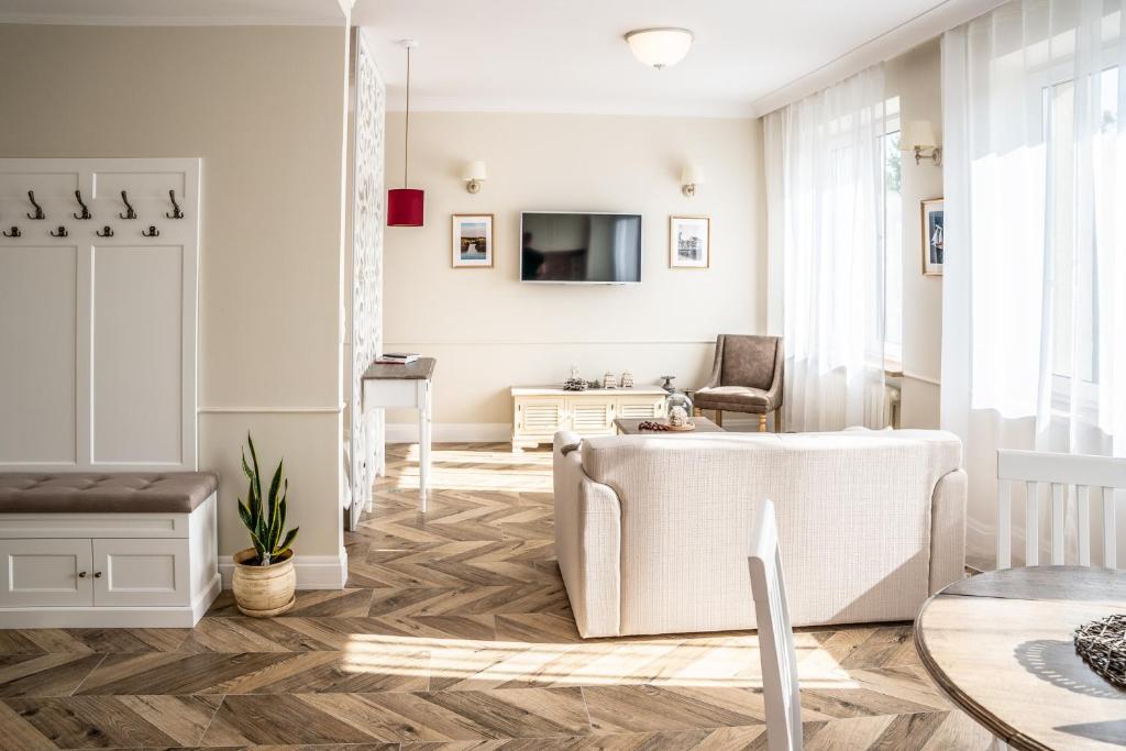 een woonkamer met een bank en een tafel bij Mazury Rest Apart in Giżycko