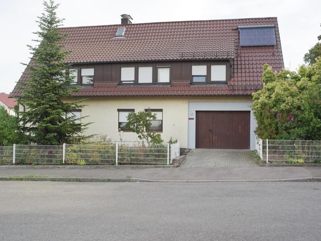 a house with a brown door and a fence at Ferienwohnung Auszeit in Bietigheim-Bissingen