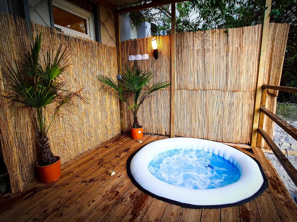 a bath tub on a wooden deck with two plants at PARADISE sur Mer, Terrasse, Spa,Proximité Nausicaa, Plage, Restaurants in Boulogne-sur-Mer
