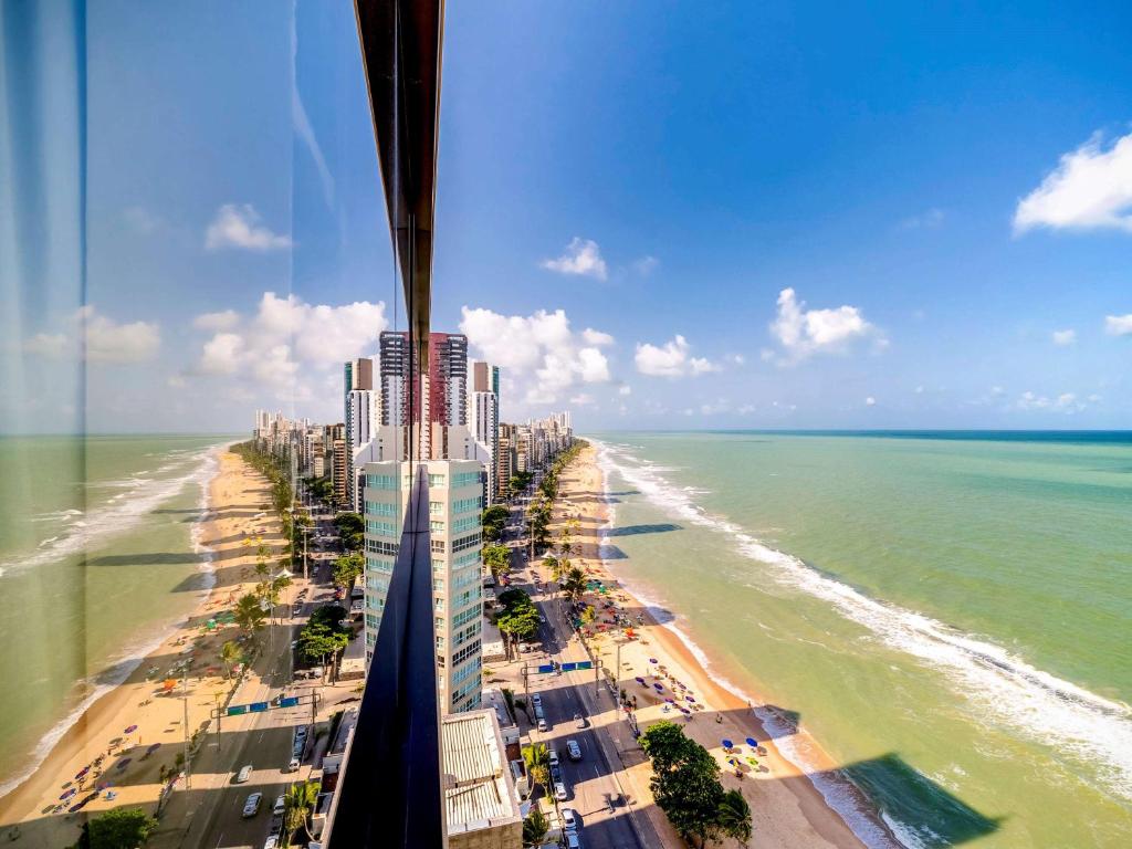 vista para uma praia e edifícios e para o oceano em Grand Mercure Recife Boa Viagem no Recife