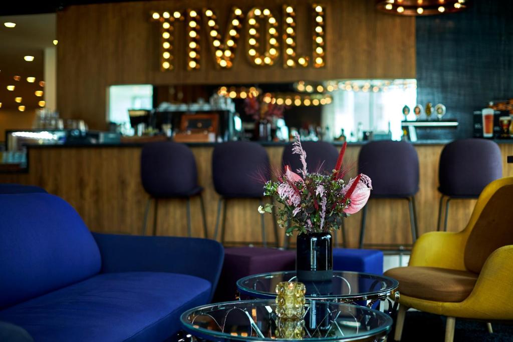 una habitación con sillas y una mesa con un jarrón de flores en Tivoli Hotel en Copenhague