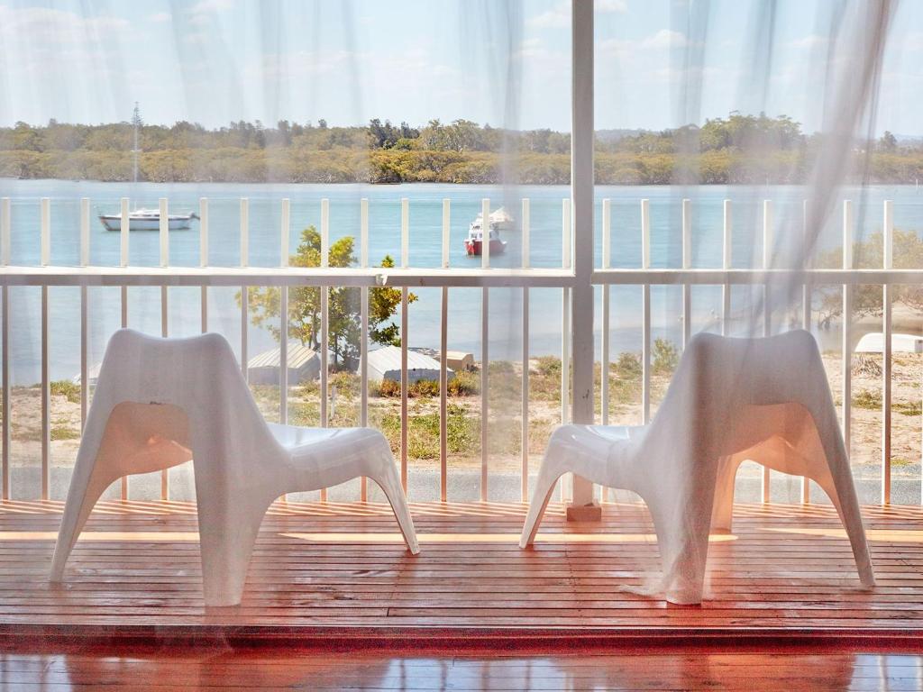 two white chairs sitting in front of a window at Riverwatch in Hawks Nest