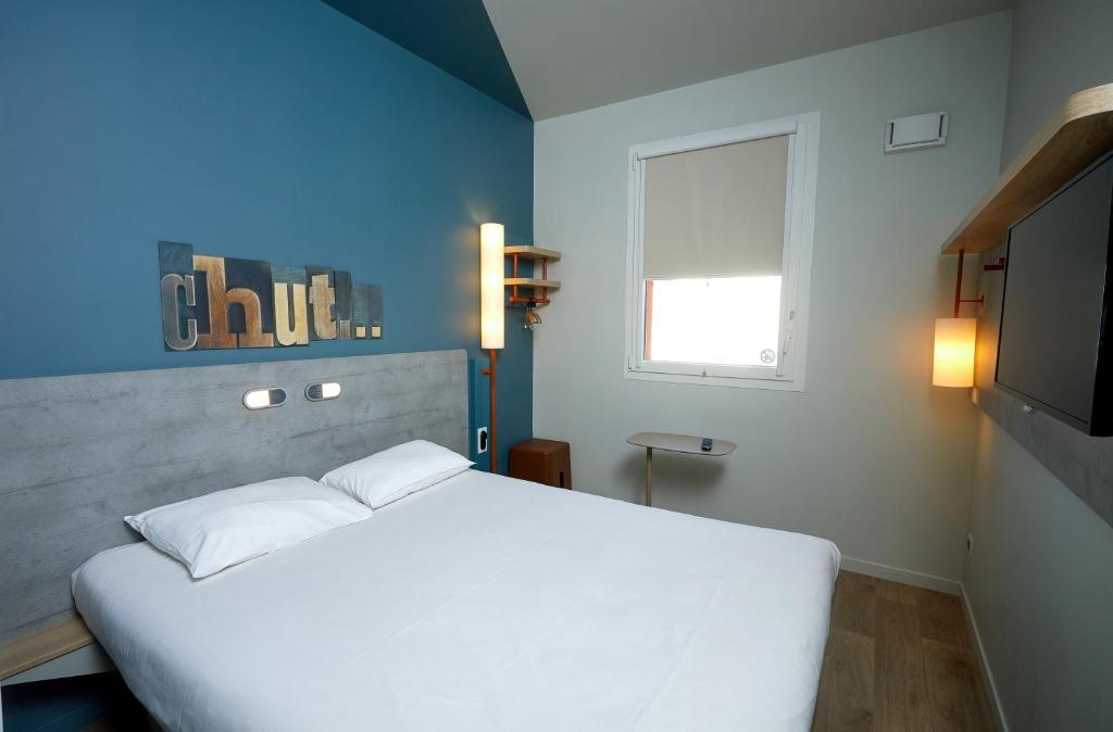 A bed or beds in a room at ibis budget Auxerre Centre