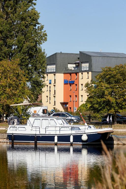 un bateau est amarré dans l'eau d'une ville dans l'établissement ibis budget Auxerre Centre, à Auxerre