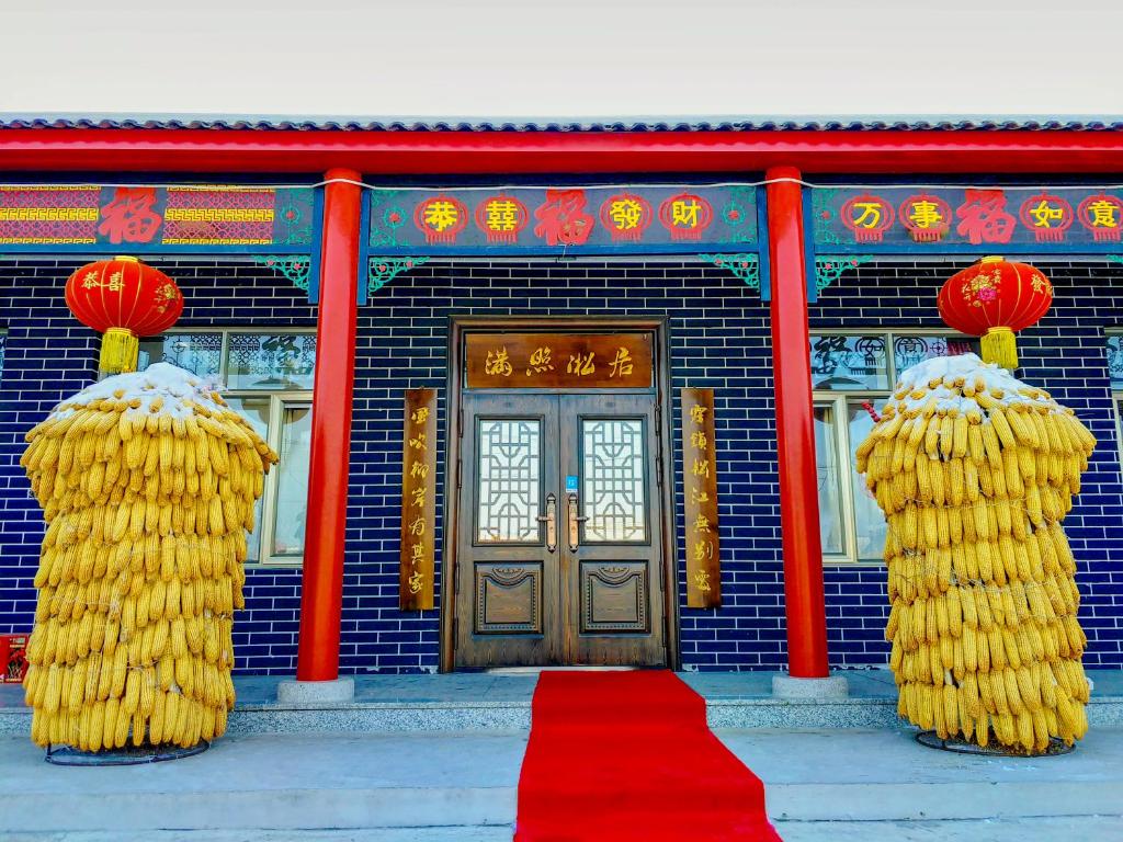 un edificio con tappeto rosso di fronte ad una porta di Rime Island Manzhaosongju Inn a Jilin