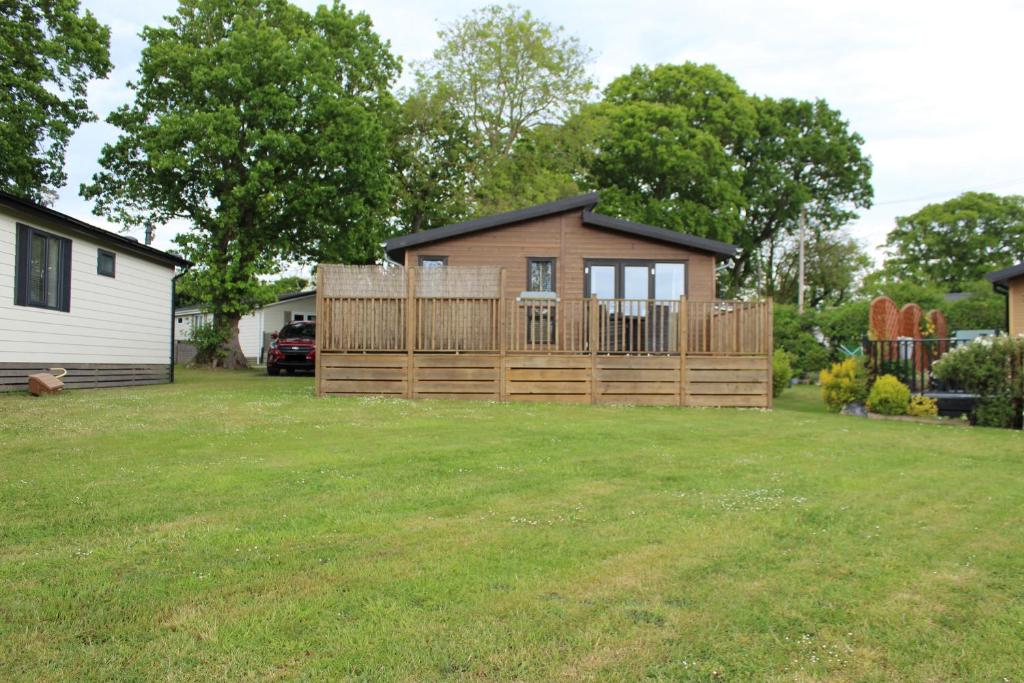 a small house with a wooden fence in a yard at 7 The Oaks in North Walsham