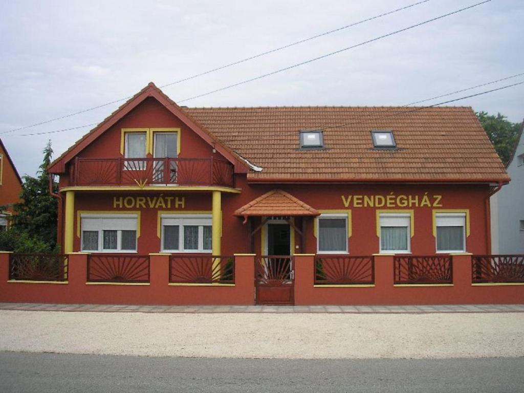 a red building with a sign on it at Horvath Vendeghaz in Hegyeshalom