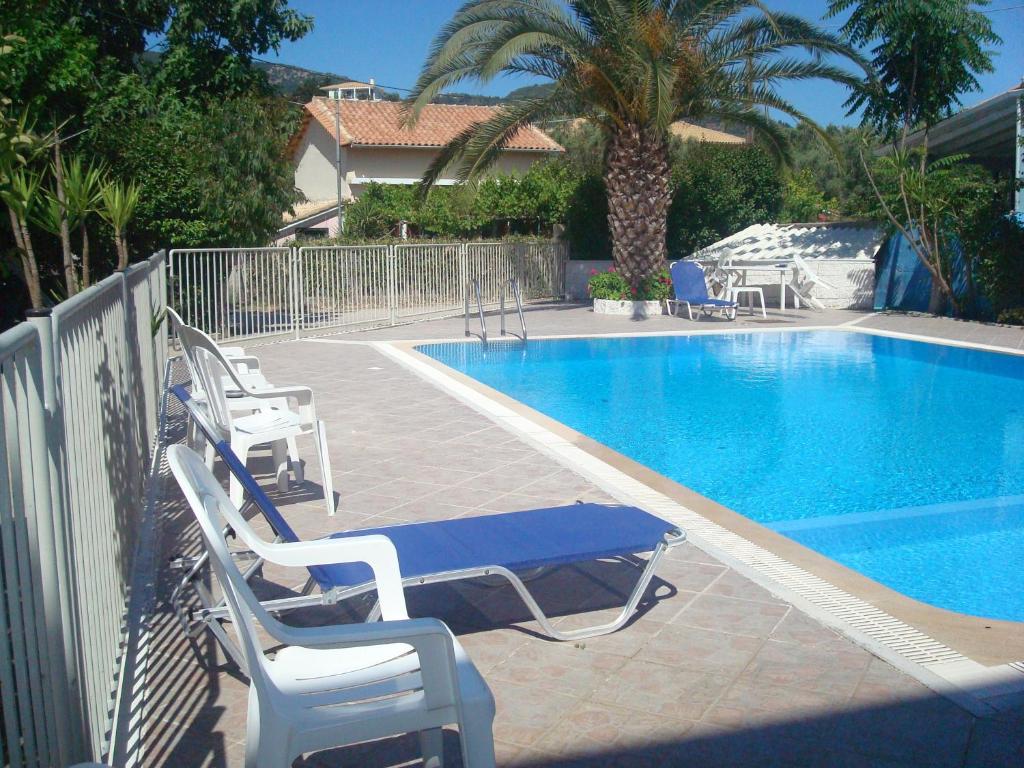 a swimming pool with two chairs and a blue table at Polyxenis Rooms in Lygia