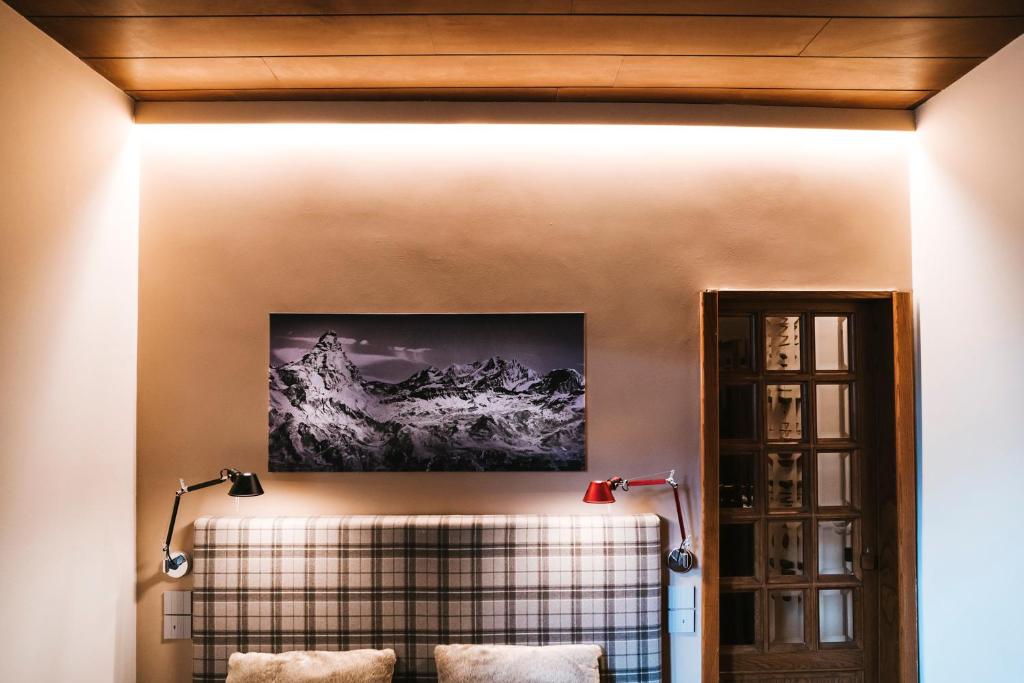 a living room with a wall with a plaid couch at THE NEST Apartment Suite Ski-in Ski-out with Hammam in Breuil-Cervinia